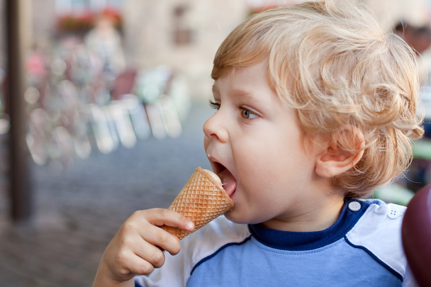 Pequeño niño comiendo helado en cono
 - Foto, Imagen