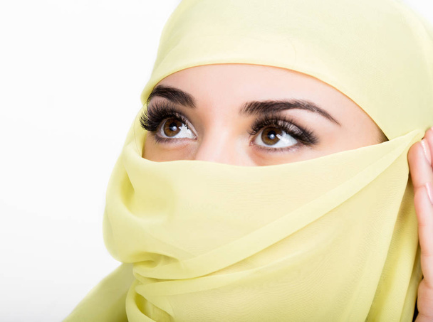 Asian girl with brown eyes posing in a yellow scarf, muslimah model in hijab isolated in white background - Photo, image