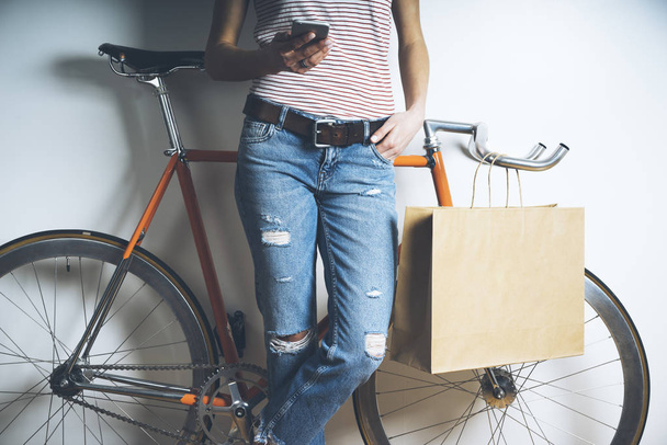 girl with bicycle using modern smartphone - Foto, Bild