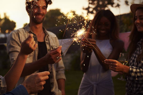Friends with sparklers enjoying backyard party - Fotoğraf, Görsel