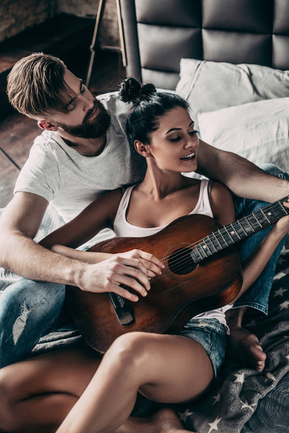 man teaching woman to play guitar - Φωτογραφία, εικόνα