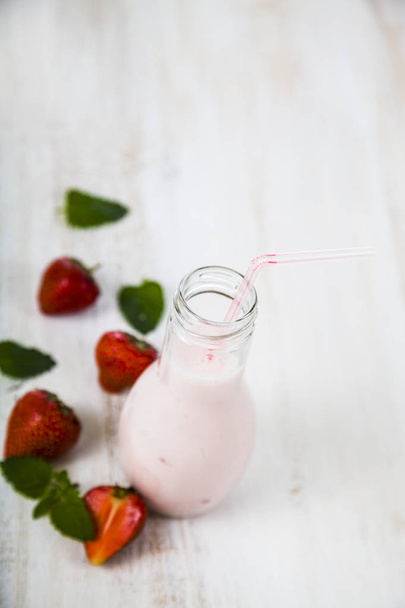 Smoothies and ripe strawberry on a wooden table.  - Photo, Image