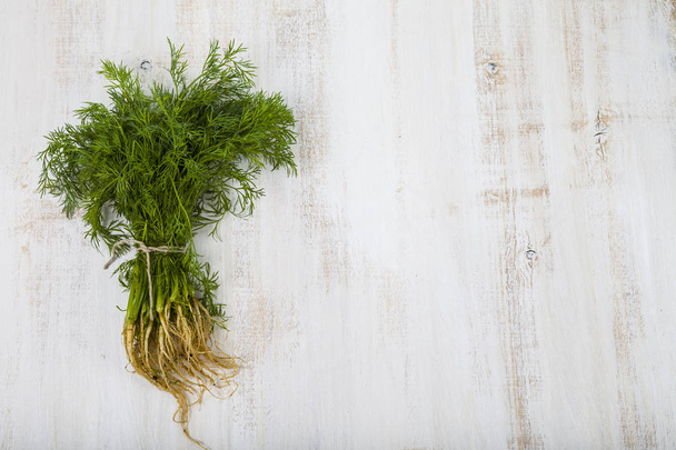 Fresh dill on a light wooden background.  - 写真・画像