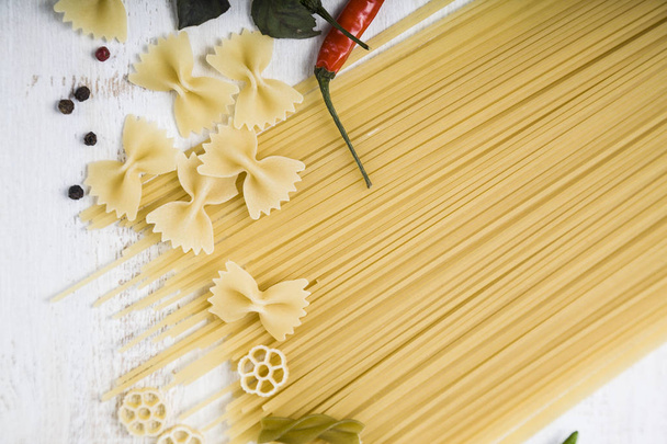 Raw pasta and spices in wooden table.  - Photo, image