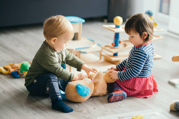 küçük kız ve erkek ev tarafından oyuncaklar ile oynama  - Fotoğraf, Görsel