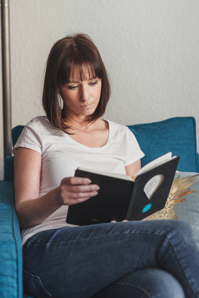beautiful woman reading a book at home - Fotó, kép
