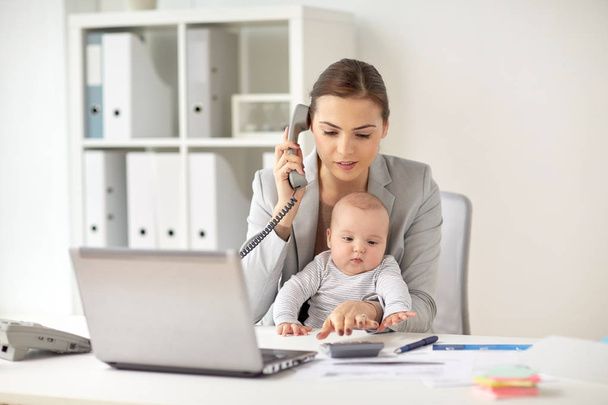 businesswoman with baby calling on phone at office - Fotoğraf, Görsel