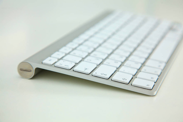 Stylowa aluminiowa klawiatura leży na stół biały - Zdjęcie, obraz