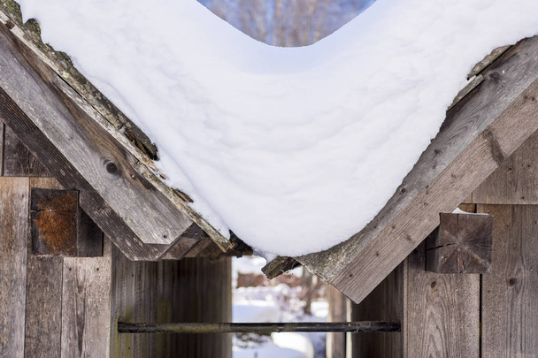 Techos de casa de madera de montaña cubiertos de nieve. Paisaje de invierno
. - Foto, Imagen