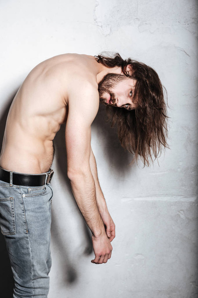 Handsome young bearded hipster man posing over wall background - Fotó, kép