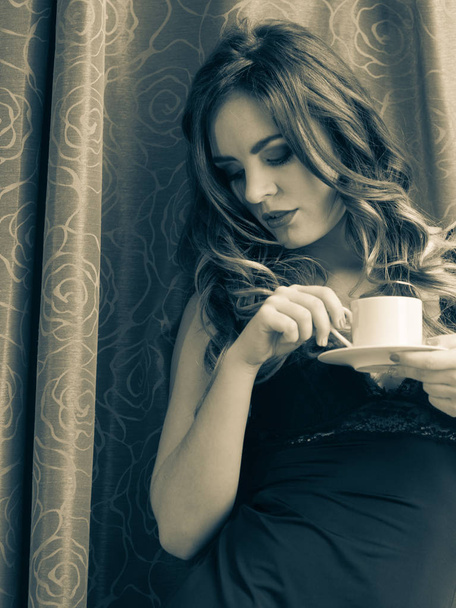 Sensual mujer bebiendo bebidas de café caliente en casa
 - Foto, imagen