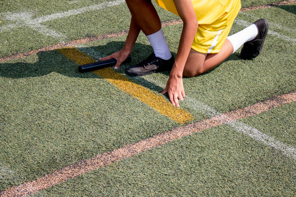 Student chłopiec przygotowuje się do rozgrzewki na sztafecie wyścigu chłopca w dniu sportu szkolnego. Koncepcja szkolnego dnia sportu. - Zdjęcie, obraz