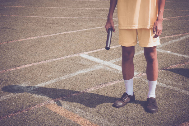 Student jongen bereidt zich voor opwarmen voor estafette race jongen op school sportdag. Schoolsportdagconcept. - Foto, afbeelding