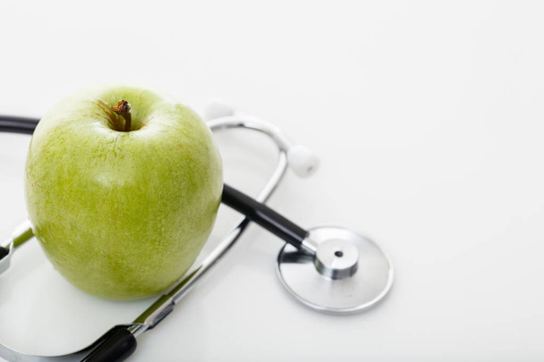 Яблуко і стетоскоп на білому
 - Фото, зображення