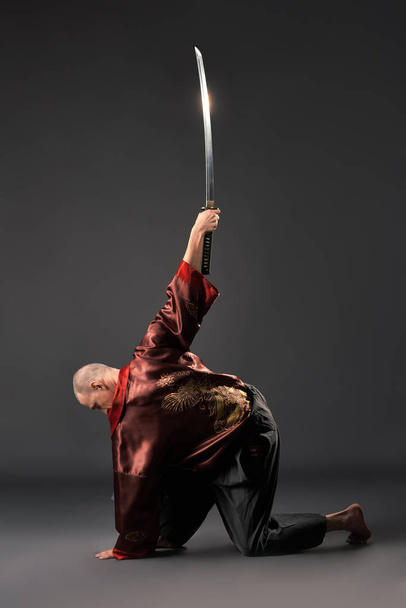 Men exercising with sword in studio - Valokuva, kuva
