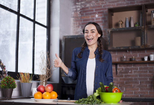 Young Woman in the kitchen. Healthy Food. Diet. Dieting Concept. Healthy Lifestyle. Cooking At Home. Prepare Food. Very Beautiful cheerful young brunette woman holding vegetables and smiling. - Photo, Image