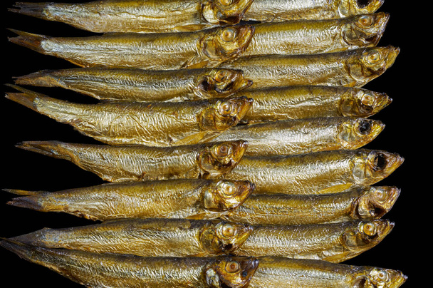 arrangement with lots of fresh smoked sprats in black back - Photo, Image