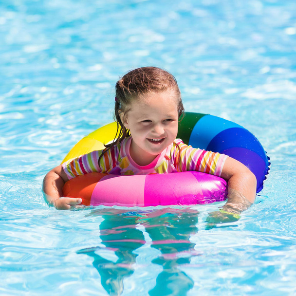 Little girl with toy ring in swimming pool - Foto, imagen