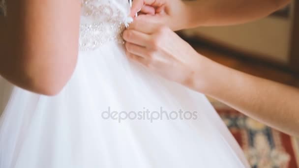 Preparación de la boda, vestido de novia siendo atado por la dama de honor
 - Imágenes, Vídeo