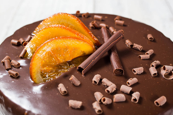 κέικ σοκολάτας με ζαχαρωμένα πορτοκάλια, κέικ σοκολάτας με ένα κομμάτι περικοπή και λεπίδα σε γκρίζο φόντο, closeup, σκοτεινό κέικ σοκολάτας, σοκολάτα νόστιμα vegan κέικ, νόστιμο κέικ σοκολάτας σε φόντο ξύλινη - Φωτογραφία, εικόνα