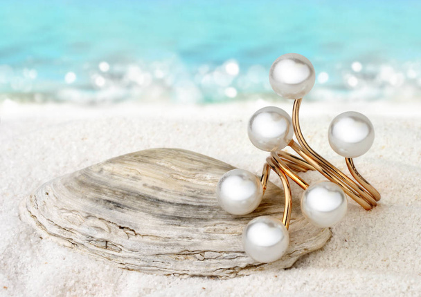 Gold Jewellery ring with pearls on sand beach background, soft f - Fotografie, Obrázek