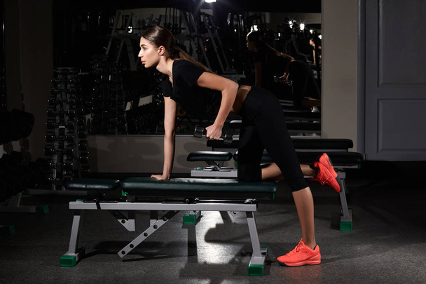фитнес-женщина накачивает мышцы гантелями в тренажерном зале
 - Фото, изображение