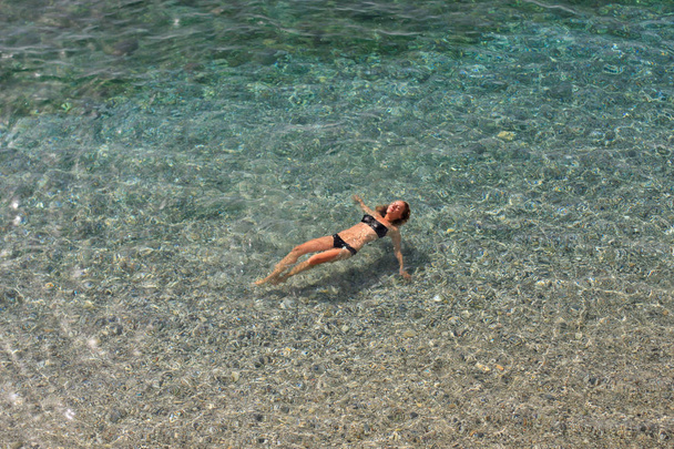 Kaunis nainen bikineissä uiminen kirkkaassa meressä
 - Valokuva, kuva
