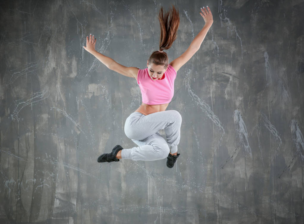 Hip hop dancer dancing on gray background - Valokuva, kuva