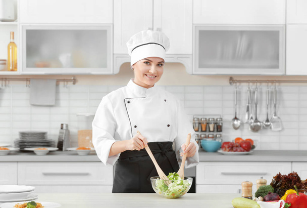 Молодая женщина шеф-повар салат на современной кухне
 - Фото, изображение