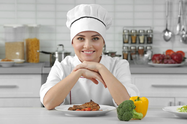 Fiatal nő szakács, hústartalmú étel a lemez - Fotó, kép