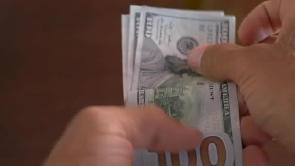 Nahaufnahme eines Geschäftsmannes, der Hundert-Dollar-Scheine in der Hand hält - Filmmaterial, Video