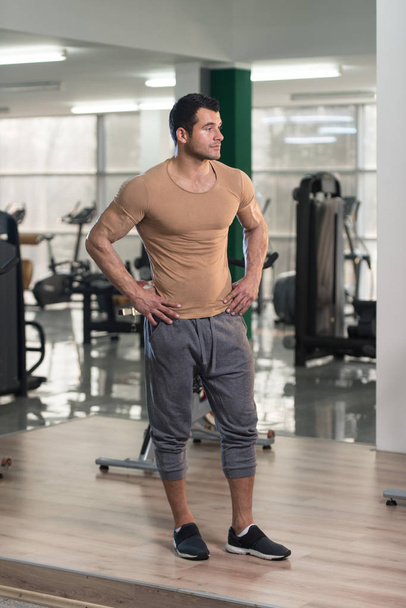 Strong Man in Brown T-shirt Background Gym - Foto, Imagen
