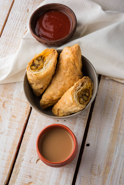 stuffed vegetable or veg puff or puf or samosa, famous indian snack menu, served with hot tea, selective focus - Photo, Image