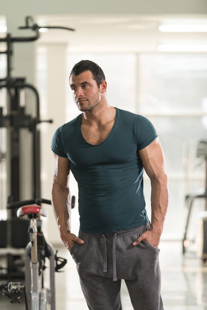 Strong Man in Green T-shirt Background Gym - Fotoğraf, Görsel