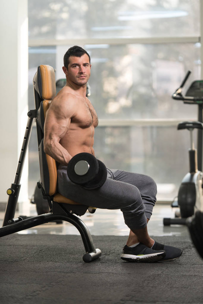 Biceps Exercise With Dumbbell in a Fitness Center - Photo, image