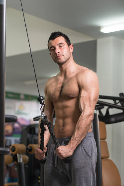 bodybuilder faisant l'exercice lourd pour des triceps avec le câble
 - Photo, image