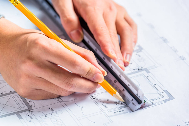 Young male architect working on plans, close-up - 写真・画像