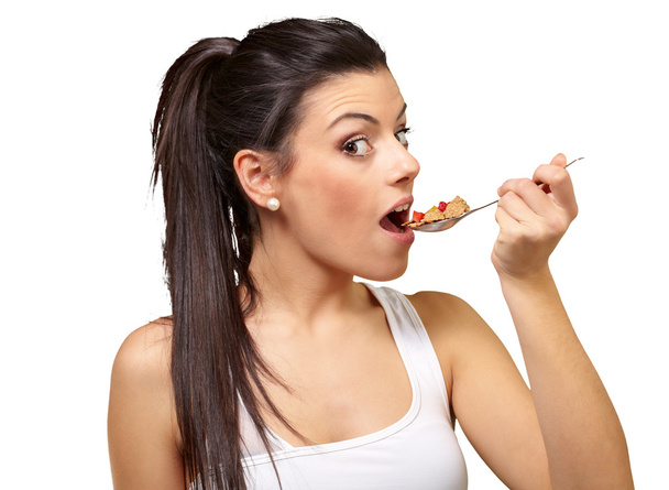 Nuori tyttö syö maissihiutaleita lusikalla
 - Valokuva, kuva
