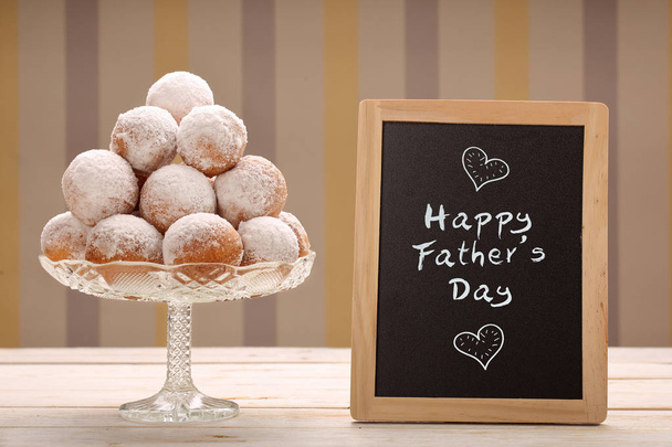 Delicious donuts and board with Happy Fathers Day inscription gr - Фото, зображення
