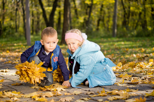 Young Children Playing Together in Autumn Woodland - Foto, imagen