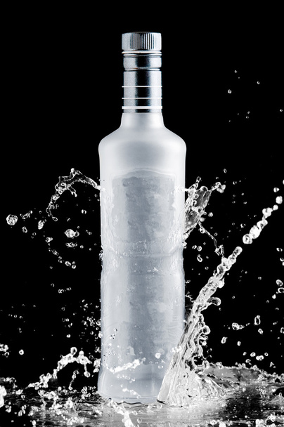 iced bottle of vodka splash on a black background - Photo, image