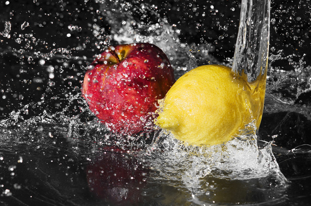 Fresh water drops on lemon and apple on black background - 写真・画像