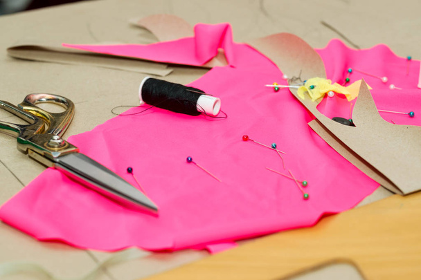 Coudre des textiles ou des tissus. Table de travail d'un tailleur. Des outils textiles. Bobine de ciseaux de fil, rubans à mesurer et tissu naturel. Espace de copie
 - Photo, image