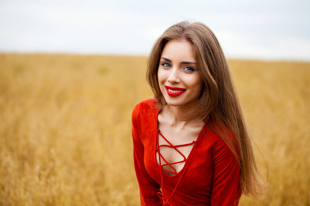 Portrait of a young brunette woman in red dress  - Fotó, kép