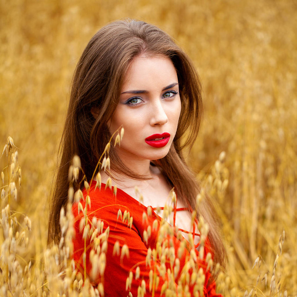 Portrait of a young brunette woman in red dress  - Fotografie, Obrázek