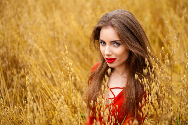 Portrait of a young brunette woman in red dress  - Fotografie, Obrázek
