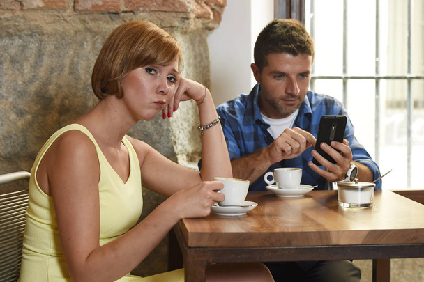 junges Paar in Coffeeshop mit Internet- und Handy-Abhängigkeit Mann ignoriert frustrierte Frau  - Foto, Bild