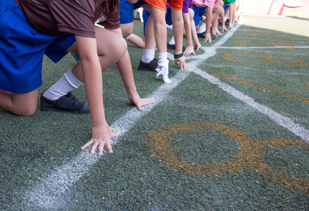 Les élèves garçons se préparent à quitter le départ pour courir garçon de compétition lors de la journée sportive de l'école. Concept de journée sportive scolaire
. - Photo, image
