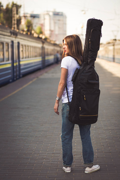 Kobieta z gitara na stacji kolejowej - Zdjęcie, obraz