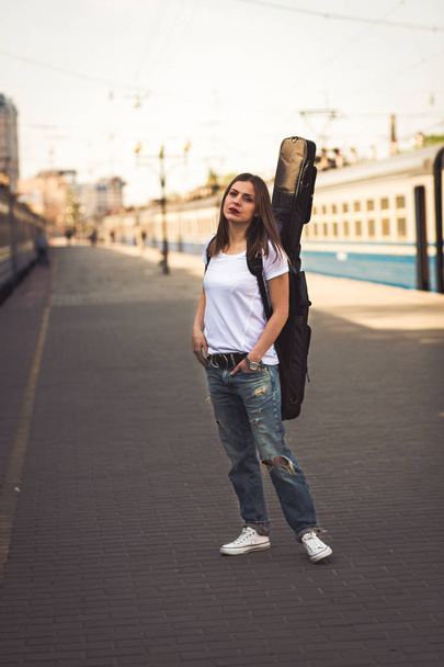 Woman with guitar at the railway station - Zdjęcie, obraz
